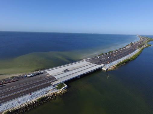 Construction of a bridge connected to a causeway through a large body of water.