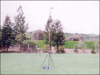 Photograph of Site 12CA showing the microphone and meteorological systems array with the barrier in the background.