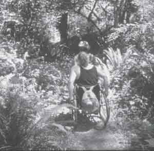 Photo of two people in wheelchairs going along a trail.