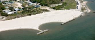 Aerial photograph of the Dauphin Island East End Beach showing the sandy expanse of the beach, with rocky bulkheads parallel to the shoreline.