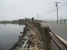 Photo shows causeway only slightly above water level with rip rap on embankment.