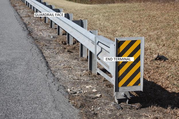Glossary â€“ photo shows example of end terminal and guardrail face.