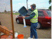 This picture shows a crew member emptying the beads in the plastic bucket into a transparent volume gauge to determine the total volume of beads that were collected in the bucket