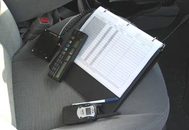 This picture shows a data sheet, a DMI, and a radio, all placed onto the right front seat of the test vehicle.