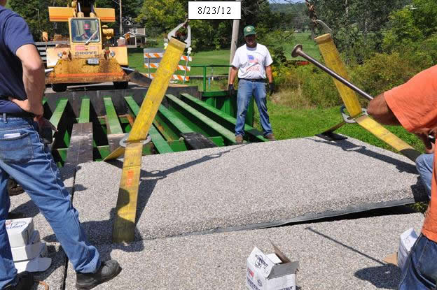 Figure 16. Photo. Place prefabricated deck panels so transverse field joints are as tight as possible, making fine adjustments with a steel road bar.