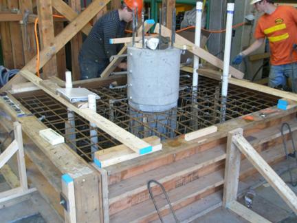 Figure 15. Photo. Construction of spread footing test specimen. Construction of the spread footing connection test specimen. The reinforcing steel for the cast-in-place footing is placed around the lower segment of the precast concrete column.