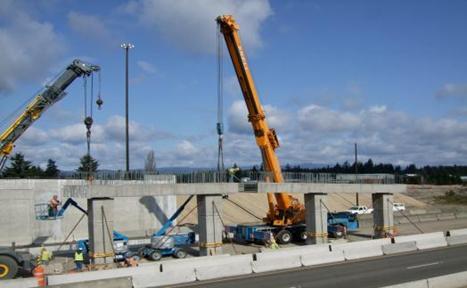 Figure 47. Photo. Precast cap beam placement. The two precast cap beam segments are lowered into place on top of the four intermediate columns.