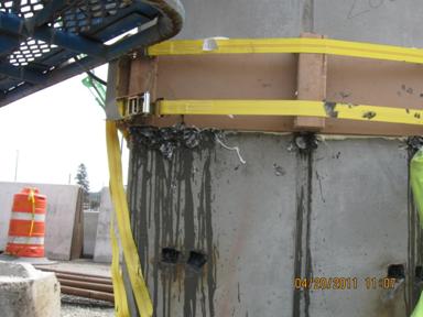 Figure 52. Photo. Difficulty with sealing the column segment joint during grouting. A close-up view of the column segment grouted joint during the grouting operation. Grout can be seen leaking from the outer forms.