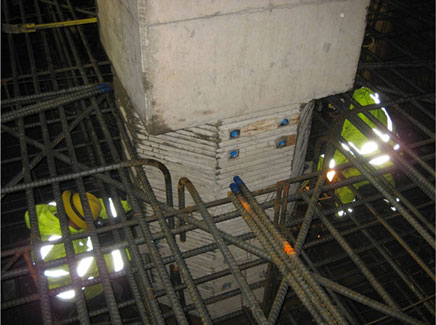 A prototype square column with an octagonal socket connection is lowered into place during construction.