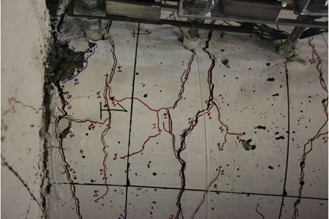 Photo shows a large column flexural crack forming near the column-to-spread footing interface. Cracks are forming about 2 inches, 8 inches, and 12 inches above the interface.
