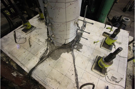 Photo shows the condition of the specimen before the last cycle. The column had hinged above the foundation, and major spalling occurred in the thin spread footing.