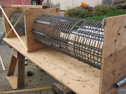The reinforcement cages for specimens SF-1 and SF-2 were tied at the same time, and the ducts were aligned. The cage closer to the viewer is the top cage, and it shows the metal ducts that connected the segment together.