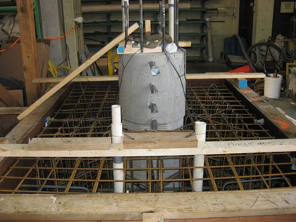 Photo shows the bottom segment of specimen SF-1’s column in place in the spread footing form. Reinforcement has been placed around the column.