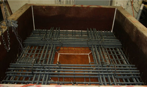 Photo shows the footing formwork and the bottom footing reinforcement. Neither the top mat nor the diagonal bars around the base of the column has been placed.
