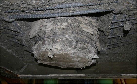 Damage to specimen SF-3 after completion of cyclic testing, viewed from below the footing. The column has punched through the footing.