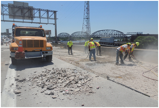 Photo. Jackhammering deck sections prior to removal.