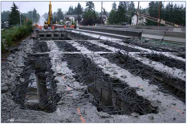 Photo showing the existing superstructure with remaining deck reinforcement protruding from the remains after deck removal