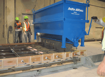 A specially designed 8' wide concrete placing bucket was used to pour the UHPC into the form. The bucket was moved along the length of the form, and the form was filled to a predetermined level of approximately 5"