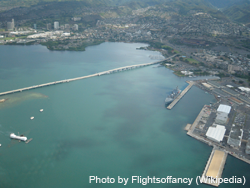 Aerial image looking northward of part of Pearl Harbor showing the USS Arizona (note oil slick), USS Bowfin and museum, Aloha Stadium, Admiral Clarey Bridge, some of the naval facilitates, and O'ahu's terrain. On the Admiral Clarey Bridge to Ford Island, you can see how part of the bridge can be moved under the right span to allow ships to go though.
