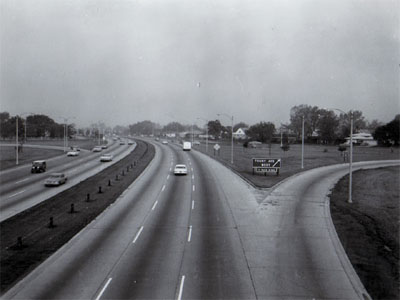 Interstate 94 (Edens Expressway) showing 6 traffic lanes, off ramp right and one ramp left, steel cable guard in median, Chicago, Illinois.