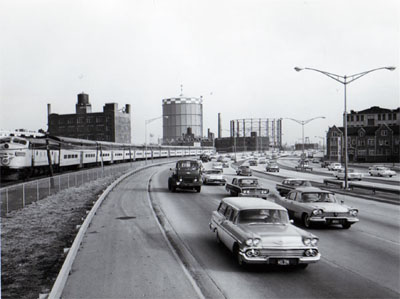 View of Northwest Expressway showing heavy traffic during peak period.  Looking East between Augusta Blvd.  And Division Street, C&NW RR on left. Chicago Illinois.