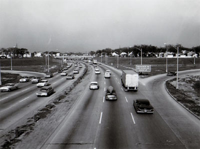 View of Congress Street Expressway looking East from Mannheim Road overpass showing heavy traffic and exit ramp right and enter ramp left.