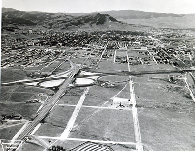 Montana - Interstate Route 15 traverses flat land as it bypasses Helena; the interchange with U.S. 12 providing ready access into town via two one-way streets.  The Continental Divide looms in the distance.