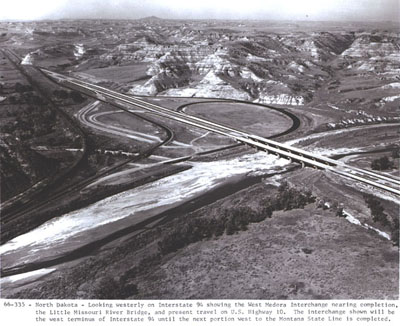 North Dakota - Looking westerly on Interstate 94 showing the West Medora interchange nearing completion, the Little Missouri River Bridge, and present travel on U.S. Highway 10.  The interchange shown will be the west terminus of Interstate 94 until the next portion west to the Montana State Line is completed.