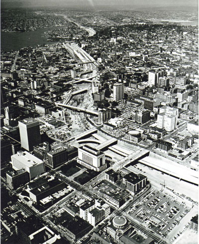 Washington - Interstate 5 is pictured as I winds through the central business district of Seattle, queen city of the Northwest.  Opening of this freeway by the end of 1966 is expected to place approximately three million people within two hours of downtown Seattle.  According to Director of Highways, Charles g. Prahl, this project will serve more people than any other transportation incomplete n cooperation with engineers and officials of the U.S. Bureau of Public Roads.