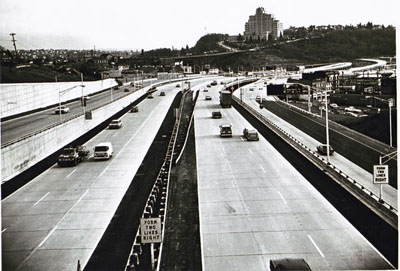 Washington - Seattle- area motorist lost little time in getting acquainted with the Seattle Freeway.  This photo, taken shortly after the ribbon-cutting ceremony, shows the prompt changeover of traffic to the new and safer highway.  The view is toward the south from the Yesler Way under-crossing bridge.