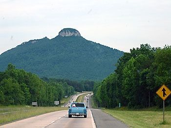 Shot of cars on road with mountain in the background.