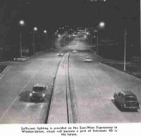 Photo of a highway.  Caption says 'Sufficient lighting is provided on the East-West Expressway in Winston-Salem, which will become a part of Interstate 40 in the future'. Click for larger version of photo.