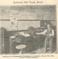 Frank Davis, who served the National Old Trails Road Association for many years, is shown in the Association's headquarters in front of a map of the trail.