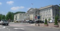 Pennsylvania Avenue disappears at 15th Street for a detour around the Department of the Treasury Building.  With renovation of the building underway, the grounds in the rear of the building are taken up by a construction staging area, seen here.