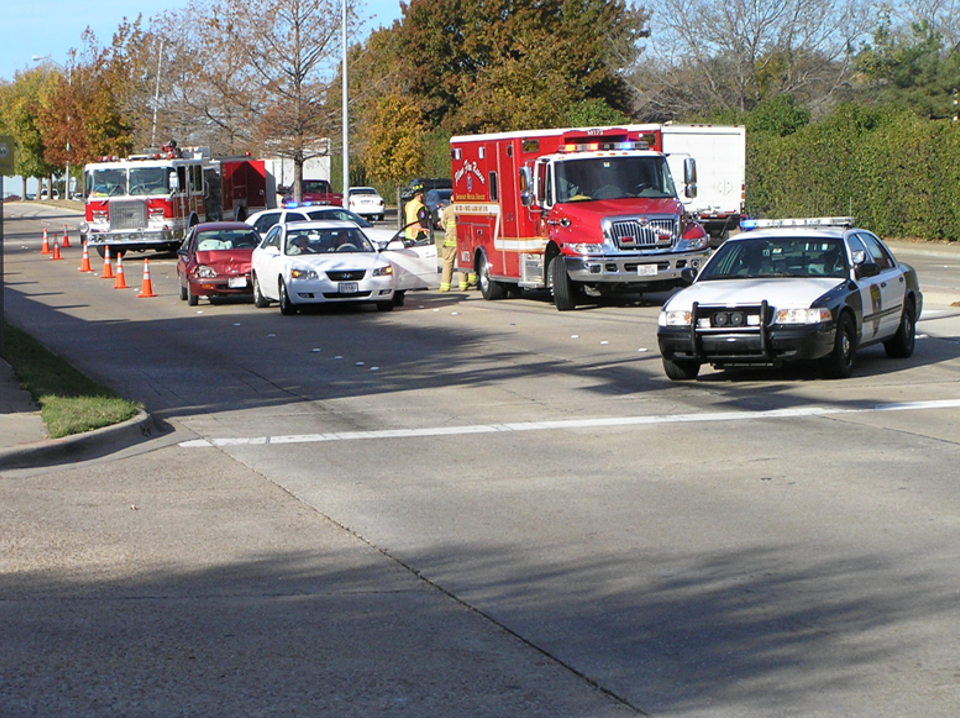 A fire truck, ambulance, and police car at the scene of a traffic incident.