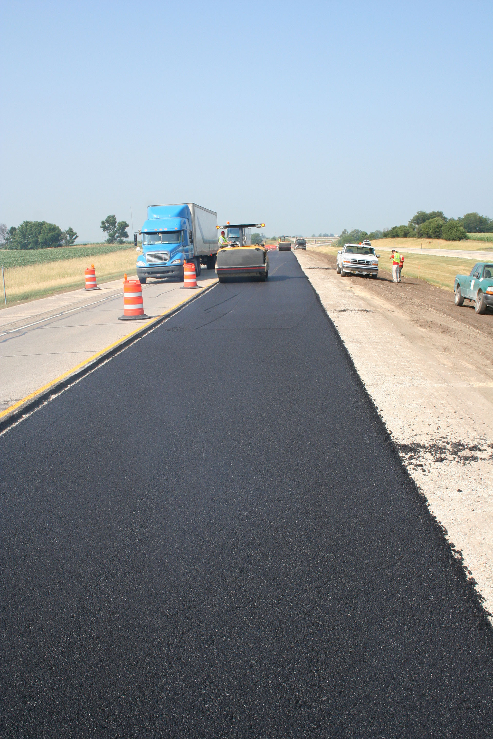 Close up of a two-lane highway with one lane of new asphalt overlay.