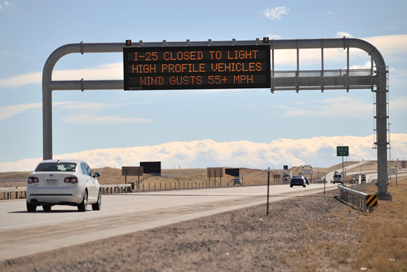 Photo of cars on road and road sign overhead