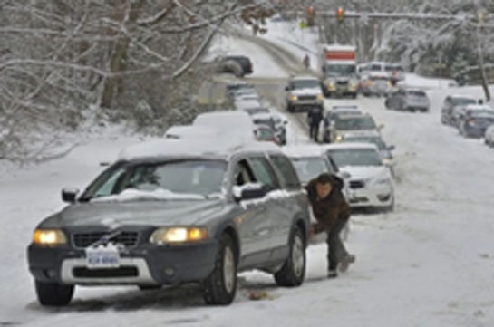 Photo of snowy roads and cars stuck in snow