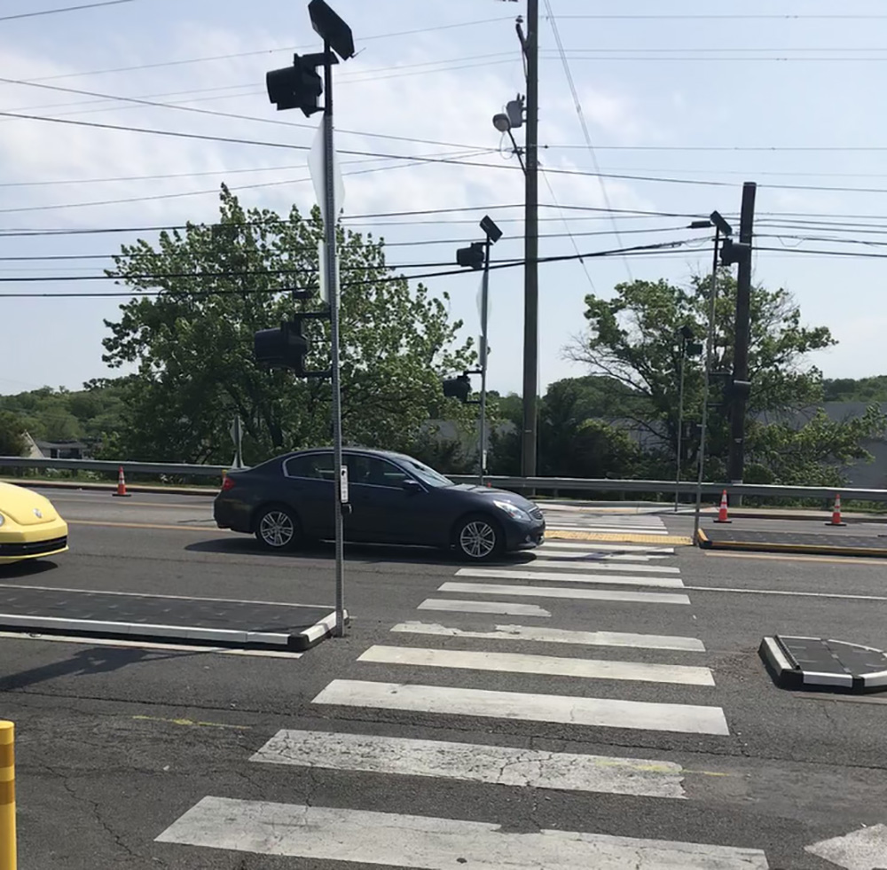 A car drives over a pedestrian crossing.
