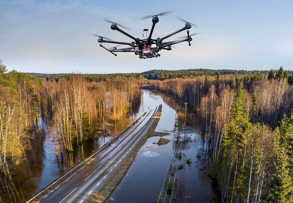 A drone flies over a partially flooded highway