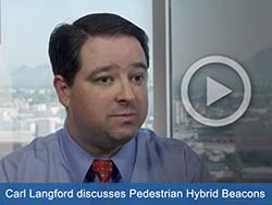 Clickable button image with picture of man being interviewed. Text states, "Carl Langford discusses pedestrian hybrid beacons."