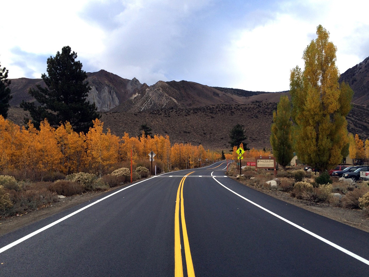 Rural highway with crosswalk near parking area for sightseers.