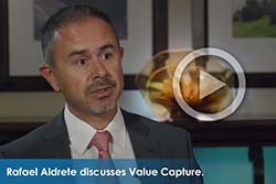 Screenshot of man being interviewed with a "play" button overlaid on it. Text at bottom of image states, "Rafael Aldrete discusses Value Capture."
