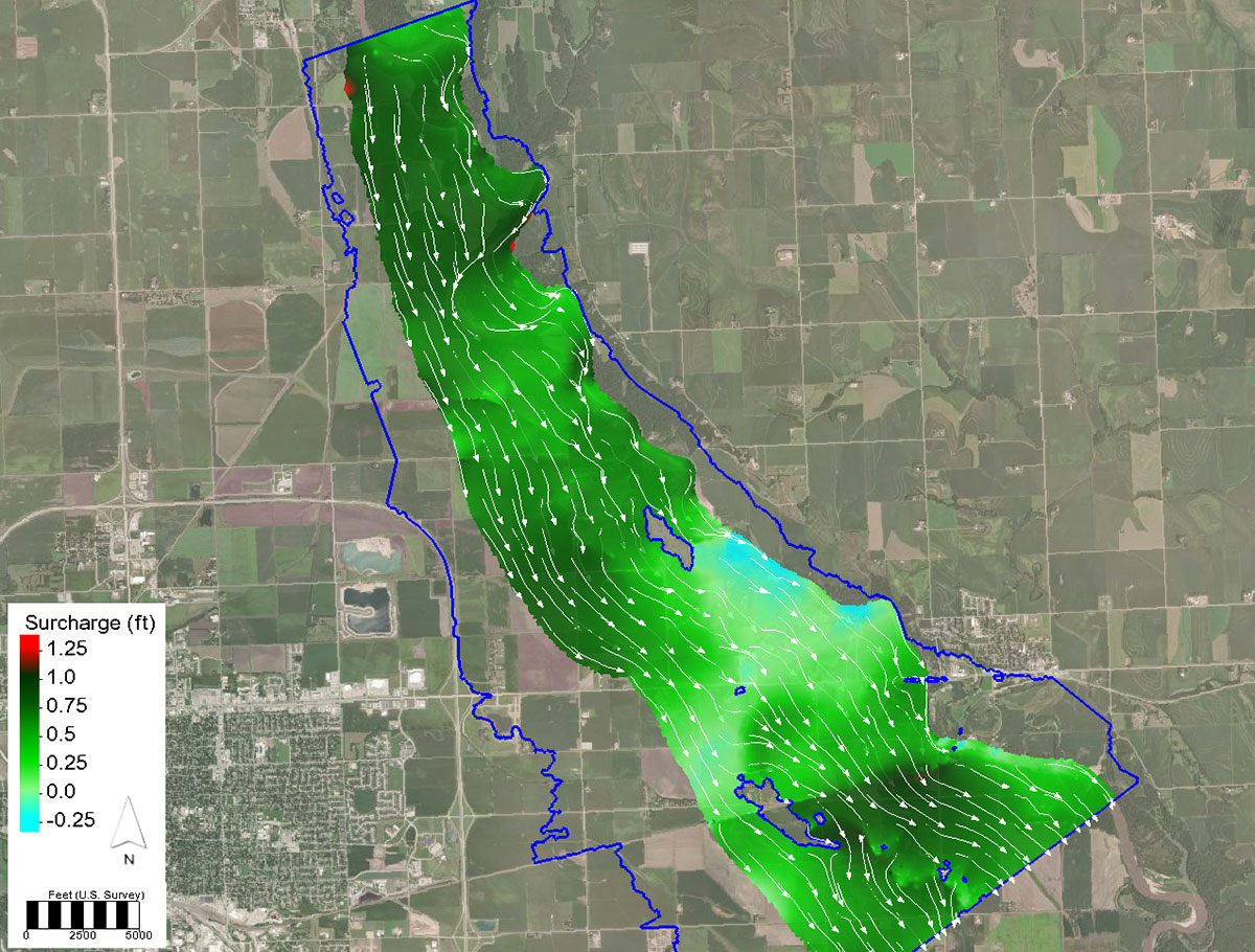 Example 2D hydraulic model floodway analysis. Flow direction is indicated by arrows and the shaded colors indicate the increase in water surface elevation.