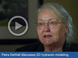 Close-up picture of woman with play button overlayed on image. Text says, "Petra DeWall discusses 2D hydraulic modeling."