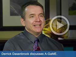 Image of man with overlaid "play" button graphic. Text states, "Derrick Dasenbrock discusses A-GaME."