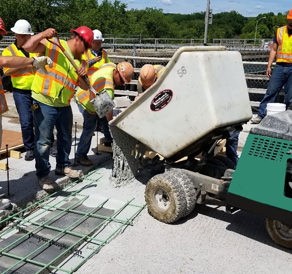 Work crew mixing and pouring UHPC into a joint region to create a UHPC link slab.