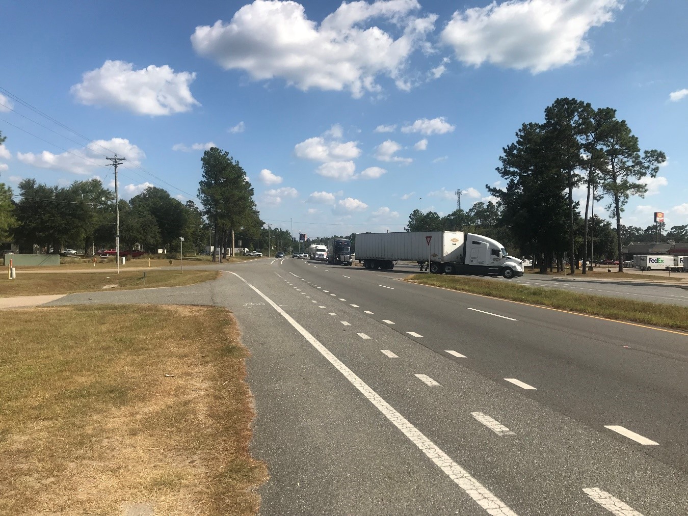 Roadway with a HiMA overlay showing several large trucks exiting.