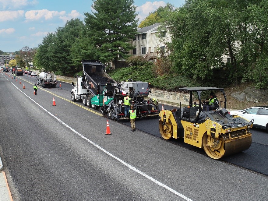 View of trucks and equipment performing road resurfacing.