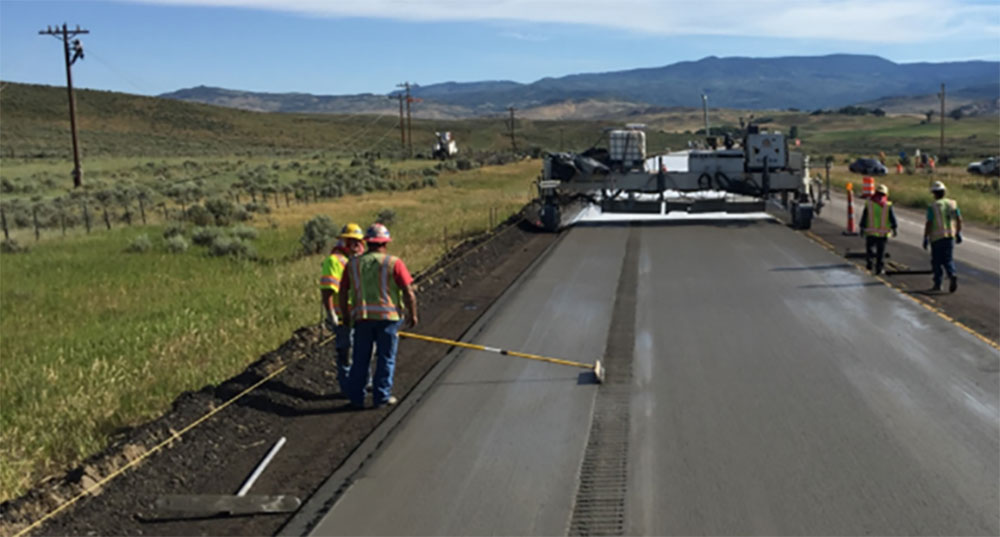 Workers install concrete overlay.